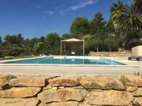a pool with a gazebo and a stone wall at Le Gîte du DAB in La Cadière-dʼAzur