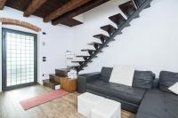 a living room with a black couch and stairs at Villa Broglia House in Verona