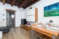 a dining room with a table and a tv at Villa Broglia House in Verona