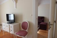 a room with a tv on a dresser and a chair at Parador Casa Da Insua in Penalva do Castelo