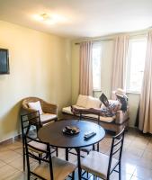 a living room with a table and chairs and a person sitting on a couch at Hotel Maharajah in Mamoudzou