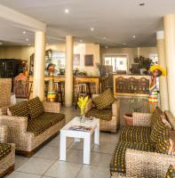 a living room with couches and a table with flowers at Hotel Maharajah in Mamoudzou
