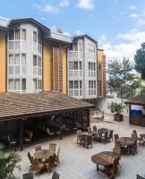 an outdoor patio with tables and chairs and buildings at Hotel Maharajah in Mamoudzou