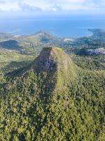 an aerial view of a mountain with trees and the ocean at Hotel Maharajah in Mamoudzou