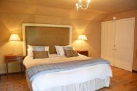 a bedroom with a large white bed with two lamps at Spring Water Barn in Helston