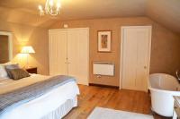 a bedroom with a bed and a bath tub at Spring Water Barn in Helston
