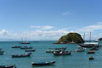 a group of boats in the water with an island at Pousada Casa do Catavento in Búzios