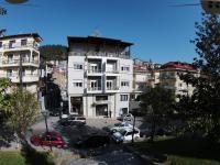 Un gran edificio blanco con coches aparcados en un estacionamiento. en Hotel Orestion - Bike and motorcycle friendly hotel, en Kastoria