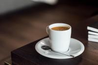 a cup of coffee on a table with a spoon at Entourage sur-le-Lac in Lac-Beauport