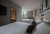 a hotel room with two beds and a television at Entourage sur-le-Lac in Lac-Beauport