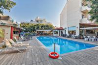 Una piscina con sillas y mesas al lado de un edificio. en Sofia Hotel, en Heraclión