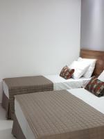 two twin beds in a room with at Pousada la Portella in Cabo Frio