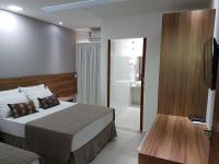 a hotel room with a bed and a bathroom at Pousada la Portella in Cabo Frio