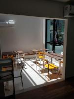 a room with tables and yellow chairs and a window at Pousada la Portella in Cabo Frio