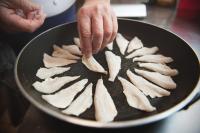 a person is holding a pan filled with food at Auberge d'Anthy in Anthy