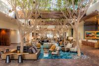 un vestíbulo con árboles, sofás y mesas en Portola Hotel &amp; Spa, en Monterey