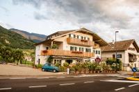 une voiture bleue garée devant un bâtiment dans l'établissement B&B Pizzeria Zur Traube, à Montagna