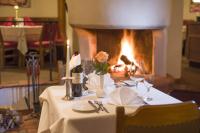 a table with a white table cloth and a fireplace at Hotel Andreas Hofer in Kufstein