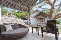 a hammock and a chair on a patio with a house at Sarikantang Resort & Spa, Koh Phangan in Haad Rin