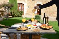 iemand die sinaasappelsap over een tafel met eten giet bij Hotel Molí de l'Escala in L'Escala