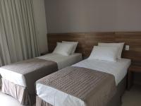 two beds in a hotel room withskirts at Pousada la Portella in Cabo Frio