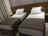 two beds sitting next to each other in a hotel room at Pousada la Portella in Cabo Frio