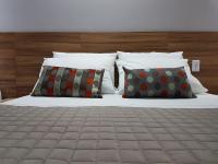 a bed with four pillows at Pousada la Portella in Cabo Frio
