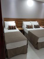 two beds in a hotel room with at Pousada la Portella in Cabo Frio