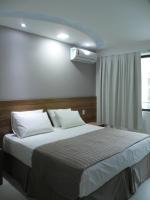 a bedroom with a large bed with white pillows at Pousada la Portella in Cabo Frio