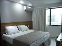a bedroom with a large bed with a window and a air compressor at Pousada la Portella in Cabo Frio