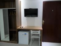 a room with a desk with a tv on the wall at Pousada la Portella in Cabo Frio