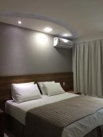 a bedroom with a large bed with a air conditioner at Pousada la Portella in Cabo Frio