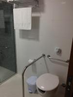 a bathroom with a white toilet and a shower at Pousada la Portella in Cabo Frio