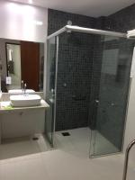 a bathroom with a sink and a glass shower at Pousada la Portella in Cabo Frio