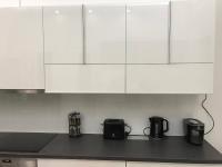 a kitchen with white cabinets and black appliances at Manyi Apartman in Debrecen