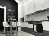 a kitchen with a table and two white stools at Manyi Apartman in Debrecen