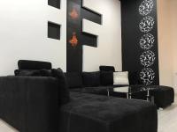 a living room with a black couch and a table at Manyi Apartman in Debrecen
