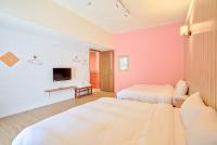 a room with two beds and a tv in it at Love Summer Hostel in Hengchun South Gate