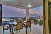 a dining room with a balcony with a table and chairs at Argus Apartments Darwin in Darwin