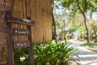 a sign on the side of a building with plants at Sarikantang Resort & Spa, Koh Phangan in Haad Rin