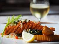 a plate of food with a glass of white wine at Sarikantang Resort & Spa, Koh Phangan in Haad Rin