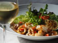 a plate of food with shrimp and a glass of wine at Sarikantang Resort & Spa, Koh Phangan in Haad Rin