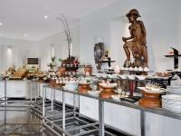 een buffet met eten en een standbeeld in een kamer bij Amagi Aria Airport Transit Hotel in Negombo