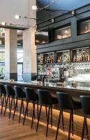 a long bar with black chairs in a restaurant at Entourage sur-le-Lac in Lac-Beauport