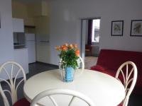 a white table with a vase with orange flowers on it at Le Buisson in Montlouis-sur-Loire