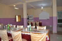 a banquet hall with a table and chairs at Hotel Maurya Vihar Bodhgaya in Bodh Gaya