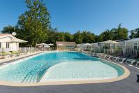 - une piscine dans un complexe avec des chaises et des arbres dans l&#39;établissement Camping Les Chèvrefeuilles, à Royan