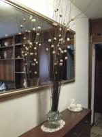 a vase with flowers in it in front of a mirror at Ca' Delfina Holiday Home in Venice