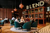 Un grupo de personas sentadas alrededor de una mesa en un restaurante. en Pullman Berlin Schweizerhof, en Berlín