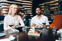 Un hombre y una mujer sentados en una mesa comiendo comida en Pullman Berlin Schweizerhof, en Berlín